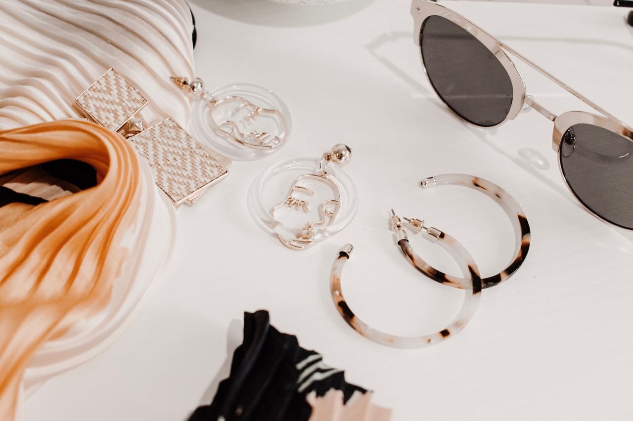 pexels-photo-2986445-2986445 Stylish flat lay of modern fashion accessories including earrings, scarf, and sunglasses.